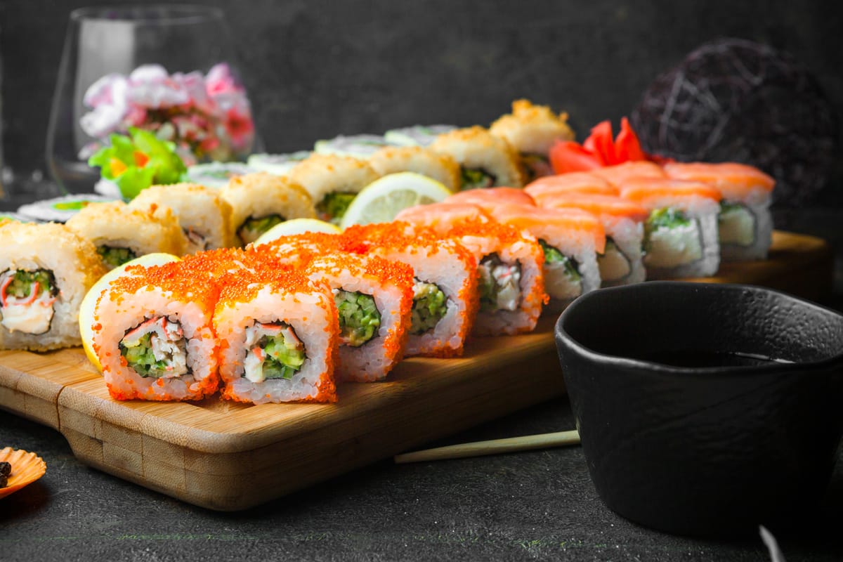 Sushi Set nigiri and sushi rolls on wooden serving board with soy